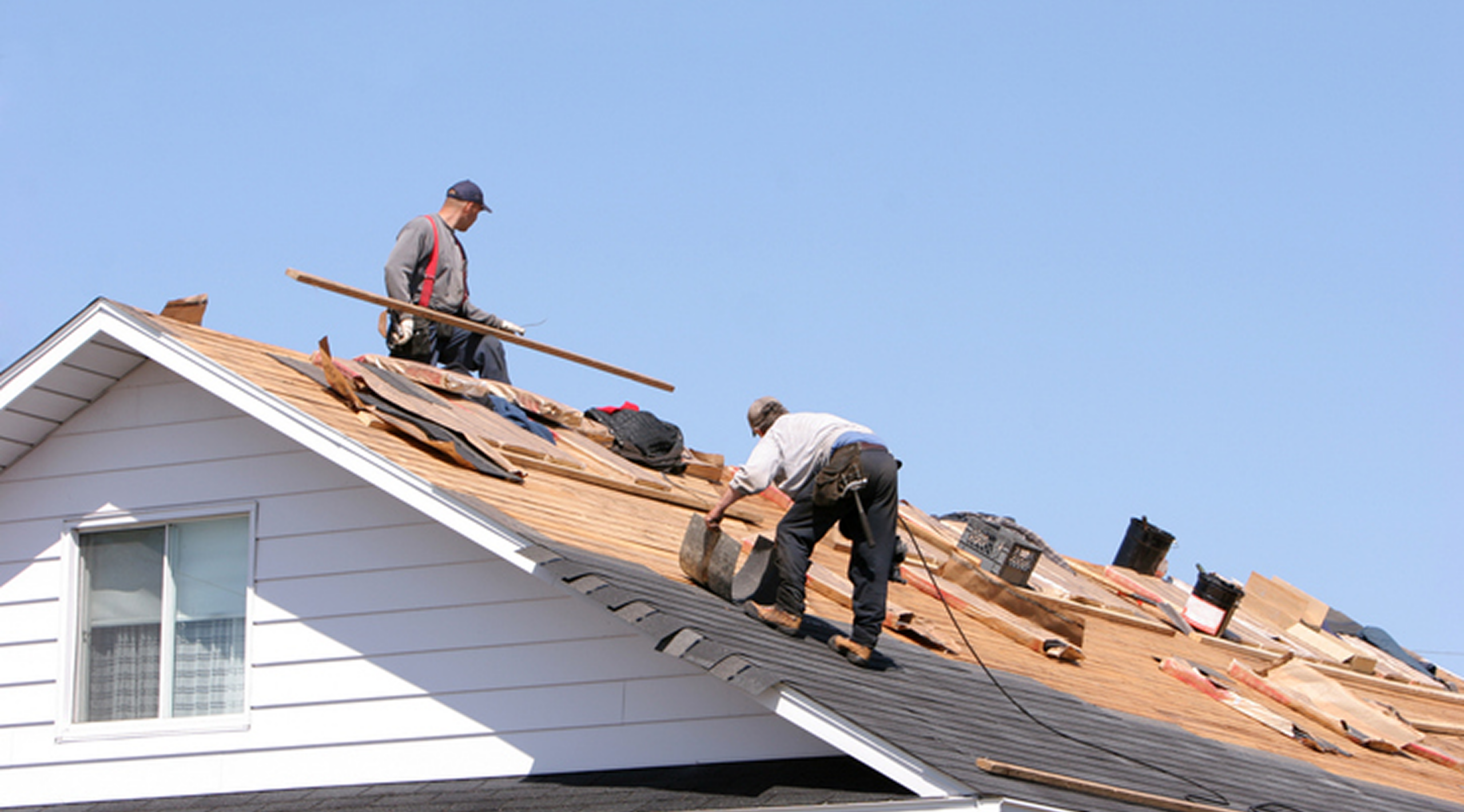 Roofers working on a house roof